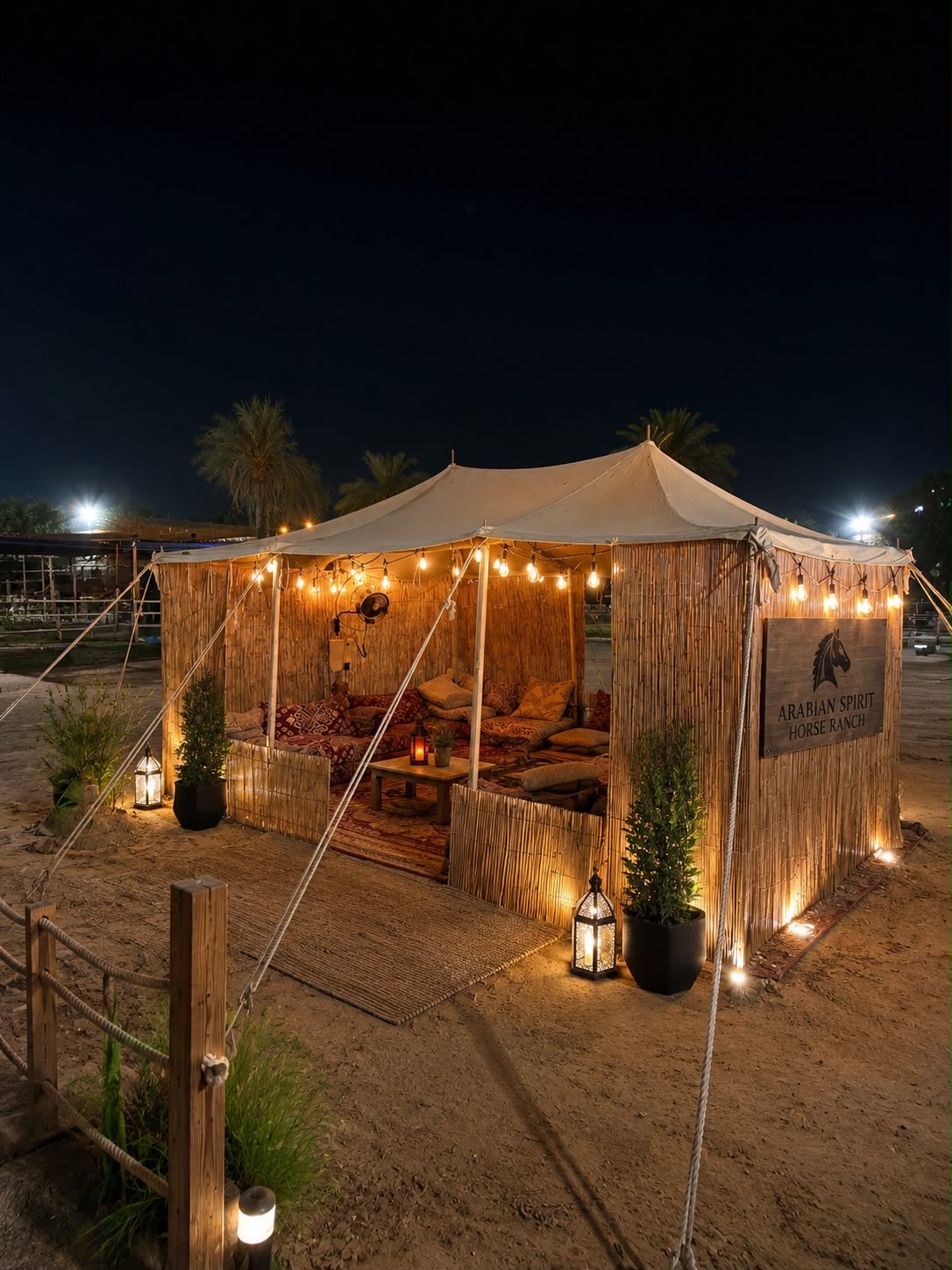 The ranch tent at night — cushions, carpets and lanterns under string lights